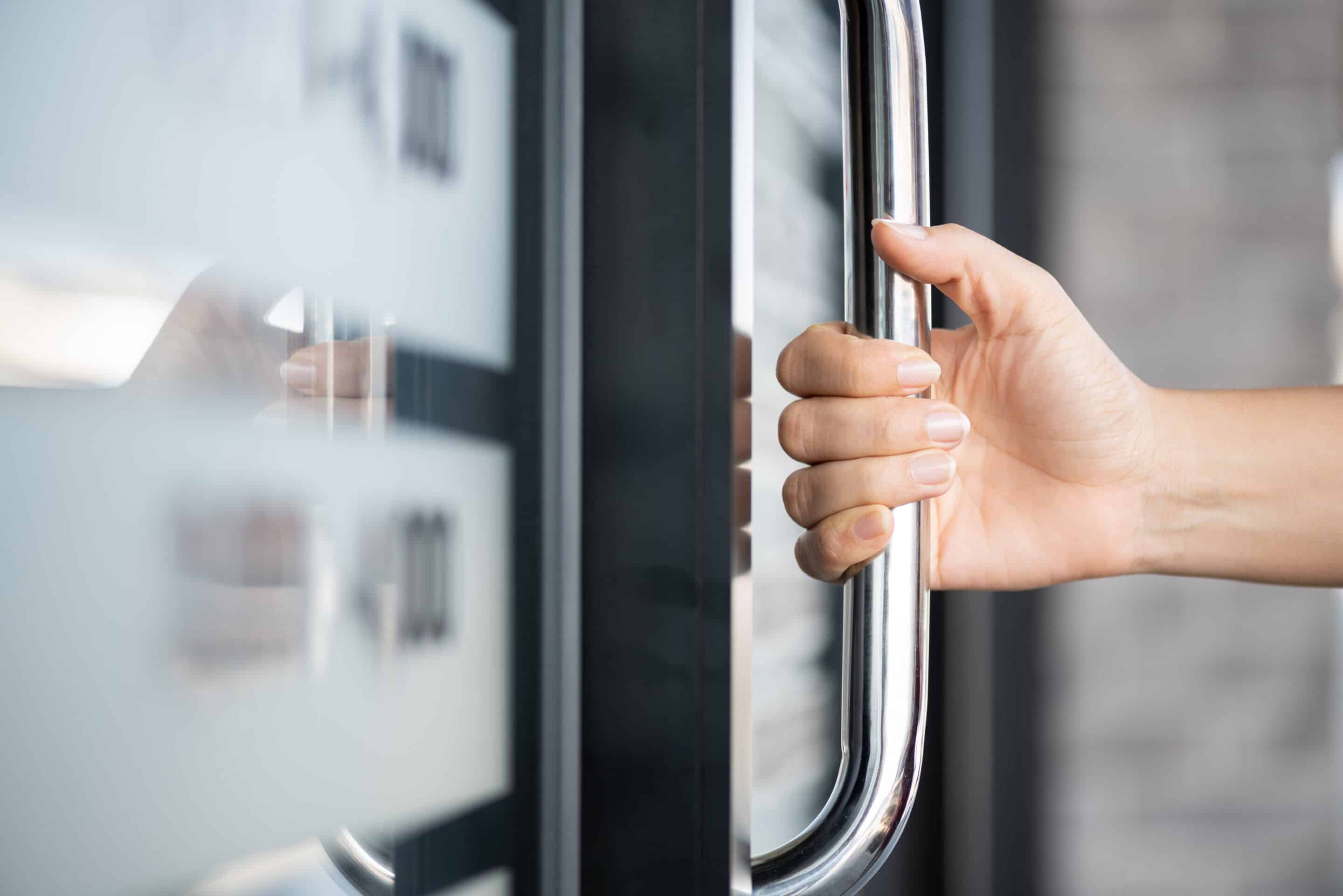 Closeup woman hand holding a door that is fail safe